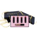 A RAGEISM BEAUTY lipstick gift set featuring four black lipsticks with pink, nude, and coral-red barrels, displayed in a pink tray with a black presentation box and gold ribbon.