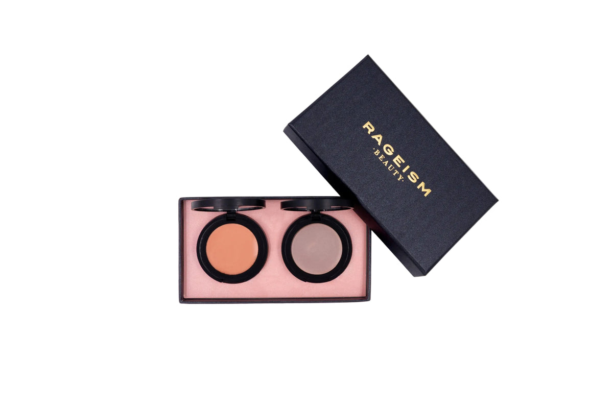 A double-pan eyeshadow palette by PAGEISM BEAUTY, shown open with two circular pans of shadow (one warm peach-orange and one taupe-brown) next to its black textured lid on a white background.